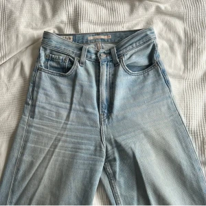 Ljusblå jeans från Levi's ”high loose” - Snygga ljusblå jeans från Levi's med klassisk femficksdesign och hög midja. Modell ”high loose” De har en straight passform och är perfekta för en avslappnad stil. 
