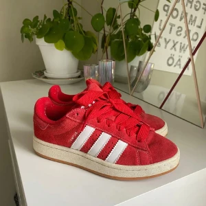 Röda adidas campus 00s - Snygga röda sneakers från Adidas med vita ränder på sidorna och en klassisk gummisula. Skorna är använda ett fåtal gånger men är i ett my ner bra skick! ‼️OBS inte mina bilder‼️ för egna bilder skriv privat
