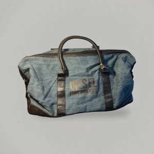 Weekendväska från Diesel - Säljer en snygg weekendväska från Diesel med  texten 'Fuel for Life'. Väskan har två handtag och en dragkedja upptill. Perfekt för en weekend semester! OBS: dragkedjan behöver lagas väskan går ej att stänga