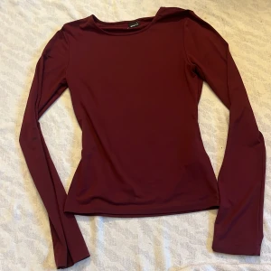 vinröd soft touch  - Säljer en stilren vinröd soft touch topp från Gina Tricot. Passar till alla årstider! Toppen har en enkel design utan mönster och är tillverkad i ett mjukt material.