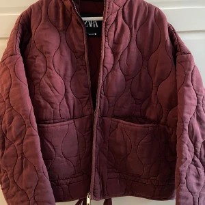 Zara quiltad jacka  - Snygg vinröd quiltad jacka från Zara med dragkedja framtill. Jackan har en hög krage och två stora fickor. Perfekt för kyligare dagar med sin mysiga och stilrena design. Helt ny! Slutsåld på hemsidan💕
