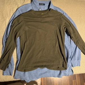 Olivgrön långärmad tröja från Ralph Lauren - Säljer en olivgrön långärmad tröja från Ralph Lauren. Tröjan har en liten broderad logotyp på bröstet och är tillverkad i ett mjukt bomullsmaterial. Perfekt för en avslappnad stil. Den är i barnstorlek men motsvarar Small lika bra. Passar unisex! Fläckfri.