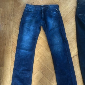 Blå jeansbyxor från Replay - Snygga blå jeansbyxor från Replay med en klassisk femficksdesign. De har en straight passform och är perfekta för en avslappnad stil. Byxorna har en dragkedja och knapp framtill.