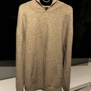 Beige hoodie  - Säljer denna beiga hoodie i riktigt najs material, den krympte lite i tvätten och är nu för liten. Den passar förmodligen dig som är mellan 185-192. Den är 70cm från axeln till midjan. Enligt mig själv så har den en riktig najs passform, inte för tajt och heller inte baggy. 