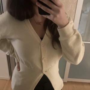 Krämvit tröja 💗 - Säljer en mysig beige kofta med knappar framtill. Den har en v-ringad design och långa ärmar, är i från pretty little thing och köptes för 500! Vid frågor hör av er!