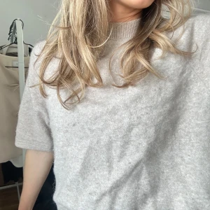 Beige kortärmad tröja - Säljer en stilren beige tröja med korta ärmar. Perfekt för en avslappnad look. Tröjan har en mjuk och bekväm känsla.