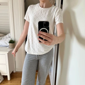 Vit broderad t-shirt - Säljer en söt vit t-shirt med broderade detaljer. Den har en normal passform och korta ärmar, perfekt för en avslappnad stil. Passar bra till både jeans och kjol. Perfekt för vår och sommar!