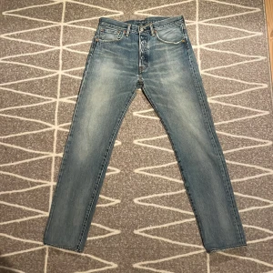 Levis 501 CT jeans - Snygga Levis 501 CT jeans i en ljusblå tvätt. Klassisk design med fem fickor och knappgylf. Perfekta för en avslappnad stil med en rak passform som ger en tidlös look.                  Storlek W32 L34