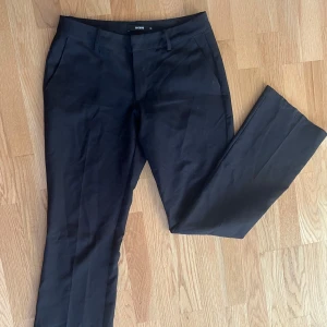 Svarta kostymbyxor  - Säljer dessa svarta kostymbyxor från BikBok. Dom är lågmidjade och utsvänga.