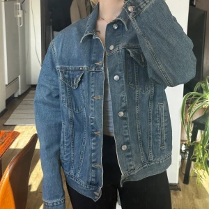 Blå jeansjacka från Rifle - Säljer en klassisk blå jeansjacka från Rifle. Jackan har en normal passform med knappar framtill och två bröstfickor med lock. Perfekt för en avslappnad stil. 🧥