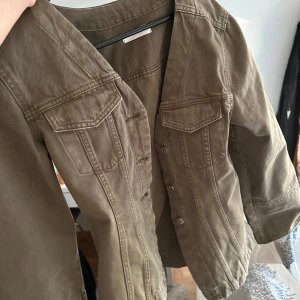 Olivgrön jeansjacka med knappar - Säljer en olivgrön jeansjacka. Snygg och enkel modell som passar till mycket. Har vanligtvis storlek S men denna är liten i storleken. Aldrig använd.