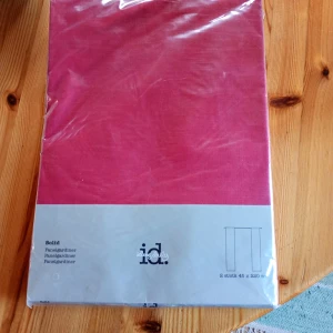 Rosa panelgardiner från i.d. - Säljer ett paket med två rosa panelgardiner från i.d. Gardinerna är 45 x 280 cm och levereras i originalförpackning. Perfekt för att ge rummet en färgklick och skapa en mysig känsla.