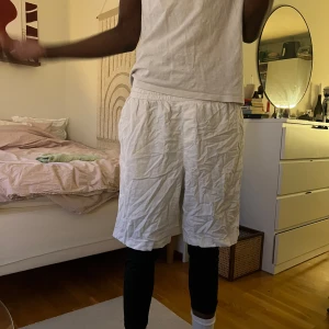 Linnéshort zara - Säljer ett par zara vita Linnéshorts med resår i midjan och lös passform. Shortsen har fickor på sidorna och en bakficka med lock.