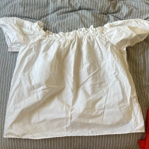 Vit offshoulderblus  - Strlk s. Knytning om man vill ovanpå axlarna, jättesöt men lite liten för mig.