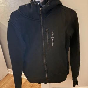Svart hoodie från Sail Racing - Säljer min svarta Sail Racing tröja nu för den har blivit för liten. Pris kan diskuteras