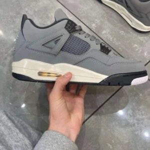 Nike Air Jordans 4 Retro cool gray - Säljer ett par Nike Air Jordans 4 Retro i grått med svarta och vita detaljer samt gula accenter på sulan och insidan. Skorna har klassisk snörning, meshpaneler på sidorna och en synlig luftbubbla i sulan. Perfekta för dig som gillar streetwear och sneakers.