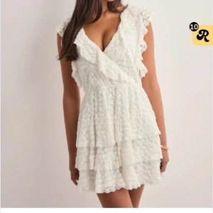 SÖKER!!! vit volangklänning med spetsdetaljer - SÖKER denna klänning ”pretty lace dress” ifrån Nelly i storlek xxs, söker akut så tveka inte att höra av er om ni har någon!