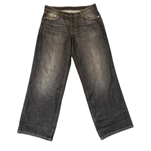 Weekday Ample Low Loose Jeans - Säljer ett par svarta Weekday Ample Low Loose Jeans med breda ben och låg midja. Avslappnad passform. Perfekta för dig som gillar en loose och trendig stil.