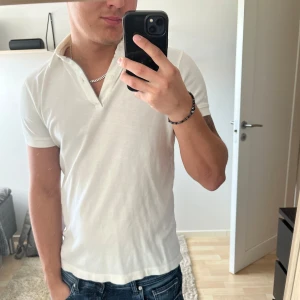 Vit pikétröja från Massimo Dutti - Säljer en klassisk vit pikétröja från Massimo Dutti i regular fit. Säljer den på den är för liten för mig.