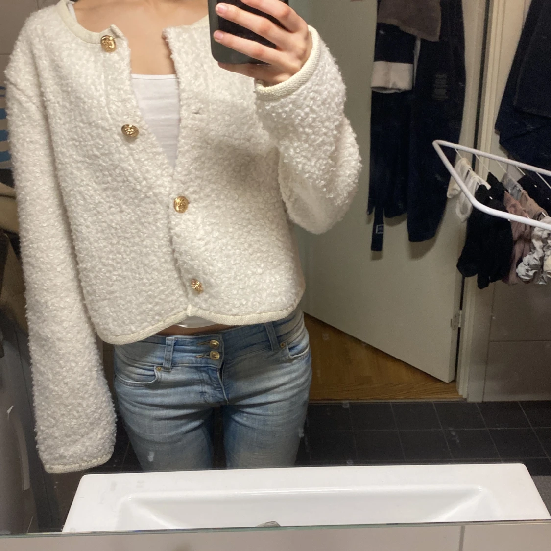 Vit kofta med guldknappar