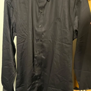 Burberry skjorta - Svart burberry skjorta i storlek M men passar bra i S också. Jätte bra skick. Vid snabbaffär priset kan diskuteras