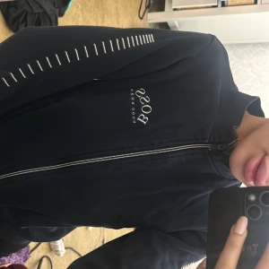 Marinblå zip-Hoodie från Hugo Boss - Marinblå hoodie från Hugo Boss med dragkedja framtill och diskret logga på bröstet. 