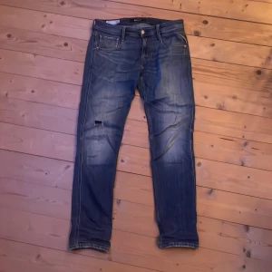 Replay anbass - Säljer ett par feta Replay anbass i storlek 30/32 de är i fint skick förutom att de har ett hål på knäet och tyget är lite lösare på bredvid sömmen där bak vilket man kan se på bilderna