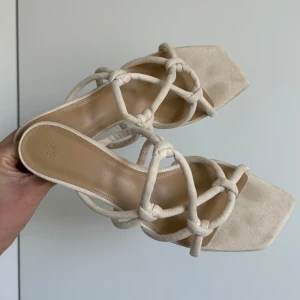 Klackar från H&M med knutdetaljer - Supersöta beige klackar från H&M med fyrkantig tå, klack och unika knutdetaljer, i mockaimitation. Passar perfekt nu till sommaren💞💞 endast använda 1 gång
