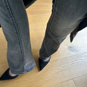 Gråa lågmidjade jeans  - Grå lågmidjade bootcut jeans från Vero Moda.