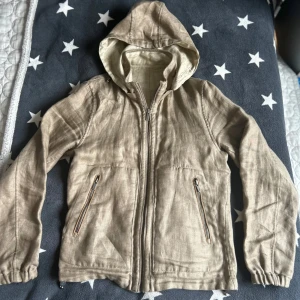 Vår cardigan från Massimo mutti  - Säljer en beige jacka med huva och dragkedja framtill. Jackan har långa ärmar och två fickor med dragkedjor. Perfekt för vår och höst. Luvan går att ta på och av och den passar perfekt till  våren. Den är i väldigt bra skick och har inga defekter. Ifall du har några funderingar är det bara att höra av sig!!!!