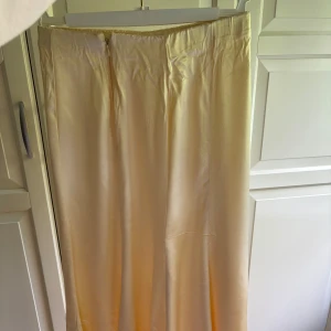 Ny gul satinkjol  - Aldrig använd. Dragkedja på sidan 