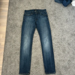 Slim Glenn jeans från Jack & Jones - Snygga blå jeans från Jack & Jones, modell Slim Glenn. Jeansen har en slim passform. Tillverkade i stretchig denim för extra komfort. Perfekta för en avslappnad och trendig look.