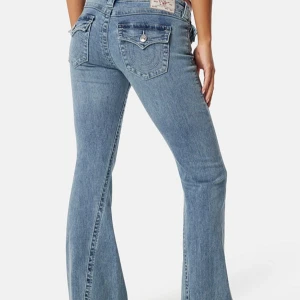 Bootcut jeans i ljusblå denim - Snygga bootcut jeans i ljusblå denim med klassiska bakfickor och dekorativa sömmar. Jeansen har normal passform och är tillverkade i bomull. Perfekta för dig som gillar en retroinspirerad look med lite utsvängda ben.