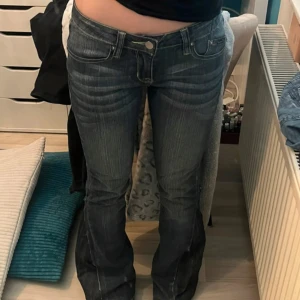 Mörkblå bootcut jeans med slits - Säljer ett par lågmidjade bootcut jeans som är sydda där nere. Storlek XS