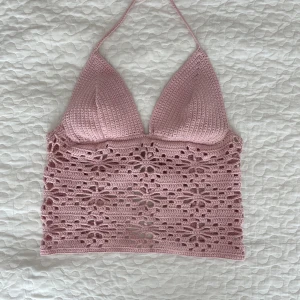 Virkad halternecktopp - Supersöt rosa egenvirkad linnetopp med knyt i nacken och ryggen. Detta gör att storleken kan justeras så att den passar dig perfekt! Toppen har ett blommigt hålmönster över magen och ryggen. Både gullig och sval under varma sommardagar!☀️Samma modell finns även att köpa i vit🤍