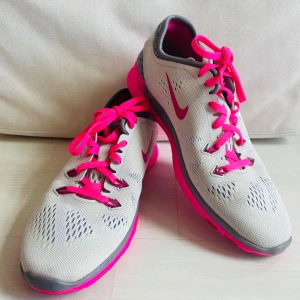 Nya Nike sneakers strl 38 - Nya Nike sneakers i mesh med ljusgrå ovandel, starkt rosa sula och snörning. I mycket fint skick! Endast provade inomhus.