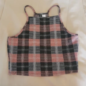 Rutig croppad topp från H&M Divided - Superfin croppad topp från H&M Divided med smala axelband. Toppen har ett rutigt mönster i svart, rosa och vitt med en lätt glittrig finish. Materialet känns mjukt och Stretchigt. 💞