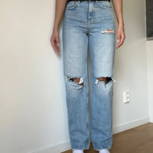 Ljusblå ripped jeans från g perfect jeans - Säljer ett par ljusblå jeans från Gina Tricot perfect jeans med snygga slitningar och hål på knäna och låret. Modellen är raka och har hög midja. Klassisk femficksdesign.
