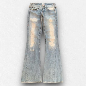 True Religions - Lågmidjade True Religion jeans med coola detaljer, Skit snygga men använder inte de. Midja-37cm och innerbenslängden är 18cm, grenmått 17 cm