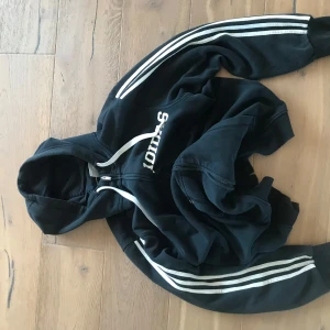 Svart Adidas hoodie med dragkedja - Fin baggy hoodie från Adidas. Storleken är L men skulle mer säga M