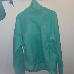 Nike ACG Therma-fit balaclava tröja M - Nike acg therma-fit wolf tree pullover hoodie. KVITTO FINNS. Köpt för 1700kr.  Den har fortfarande kvar aroman som nya kläder o skor brukar att ha.  Splitter ny, inte ens testat.