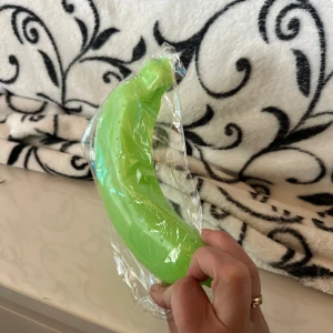 Bananfodral Bananhållare för utomhusbruk - En rolig, grön leksak i form av en banan. Perfekt för lek och skoj! Bananhållare för utomhusbruk, resor och förvaring. Sött skydd för din banan. Skydda din banan nu! 