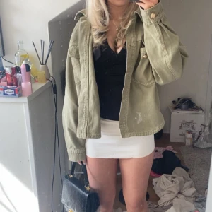 Grön jeansjacka med guldknappar - Säljer en olivgrön jeansjacka med guldiga knappar och klassiska bröstfickor., oversized passform och är perfekt att slänga över en outfit för en cool look.