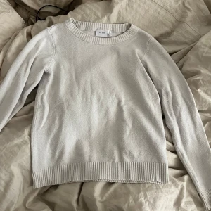 Vit stickad tröja från VILA - Säljer en enkel och stilren vit stickad tröja från VILA i storlek S. Tröjan har rund halsringning, långa ärmar och ribbade muddar vid ärmslut och nederkant. Perfekt basplagg till garderoben passar super med jeans och kjol!!