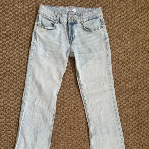 Ljusblå jeansbyxor från Pull&Bear - Så snygga lågmidjade jeans från Pull & Bear. Små i storleken så skulle säga att dem passar en storlek 36/38!