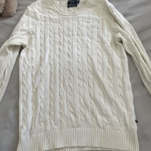 Vit kabelstickad tröja - Kabelstickad vit tröja med rund halsringning och långa ärmar. Klassisk modell med ribbade muddar och nederkant. Perfekt för lager-på-lager och passar till många olika stilar. Stl S herr! 