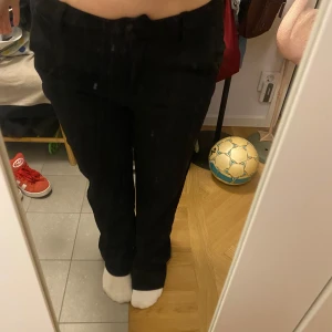 Svarta bootcut jeans - Säljer ett par svarta kostymbyxor med bootcut-passform och normal midja. Klassisk femficksmodell med dragkedja och knapp framtill. Skit sköna och snygga!!