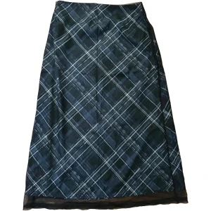 Mörkblå rutig kjol - Mörkblå midi-kjol med vitt rutigt mönster. Oanvänd. Kjolen har en diskret dragkedja i sidan och är helfodrad på insidan. Rak passform.