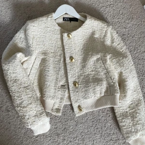 strukturstickad kofta/jacka från Zara - Säljer en favorit som är eftertraktad strukturstickad kofta/jacka från Zara. Så snygg med gulddetaljer! Går att ha på våren och sommaren. (Storlek L men absolut liten i storlek så ligger runt en xs-s skulle jag mer säga) Nypris 559