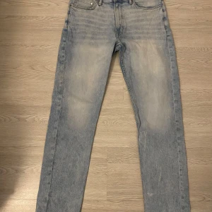Ljusblå raka jeans - Säljer ett par ljusblå jeans med klassisk femficksdesign och raka ben. Jeansen har en något tvättad look och normal passform. Perfekta för en avslappnad stil och passar till det mesta i garderoben.